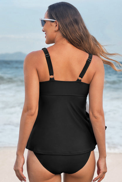 Woman wearing a black swimsuit standing on a beach with ocean view