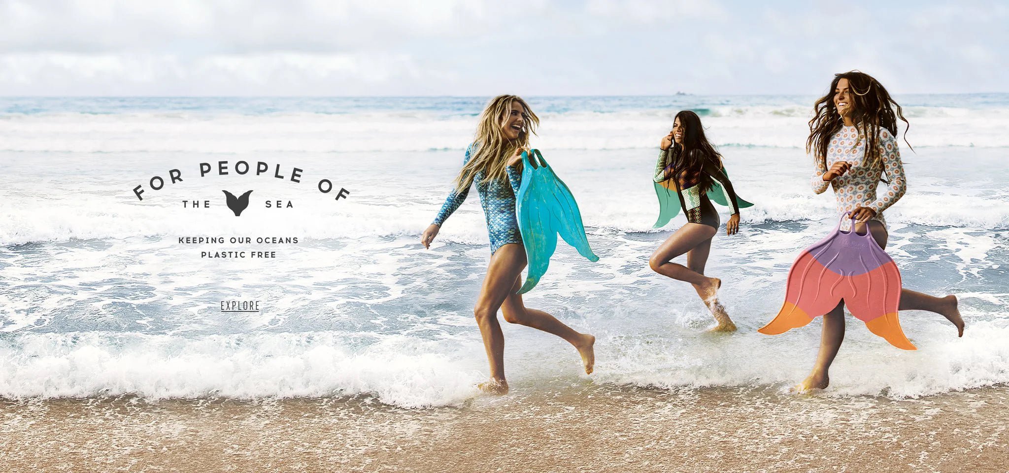 Three women running on a beach with colorful Mahina Merfins, promoting ocean conservation.